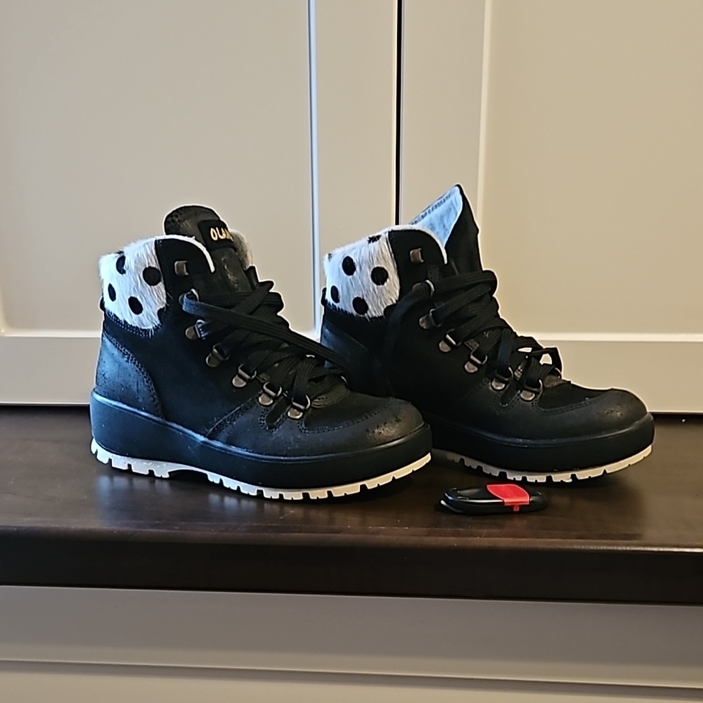 Olang ankle black boots with white trim and black polka dots.